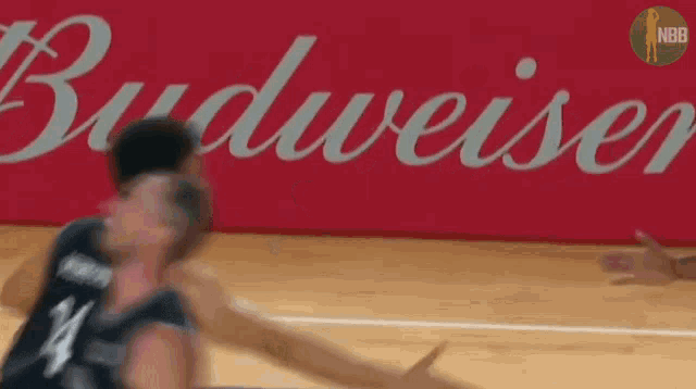 two basketball players are playing in front of a budweiser ad