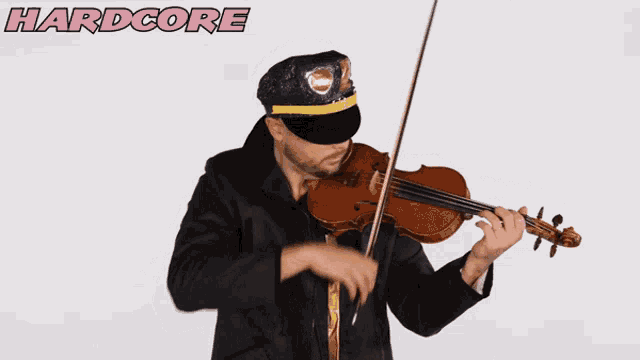 a man is playing a violin in front of a hardcore sign