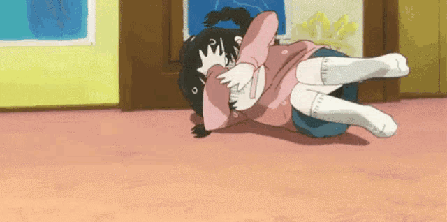 a girl in a pink shirt is laying on a man 's lap in a room