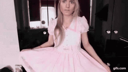 a woman is wearing a pink dress in a room .