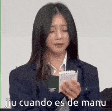 a woman in a suit is holding a notebook with the words jiu cuando es de manu written on it