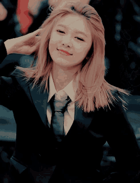 a woman with blonde hair wearing a suit and tie