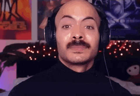 a bald man with a mustache is wearing headphones and making a face .