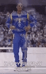 a man in a blue shirt and blue pants is standing in front of a crowd .