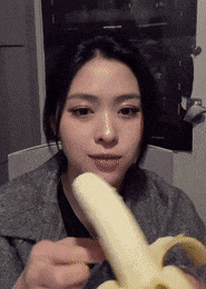 a woman is eating a banana that is peeled
