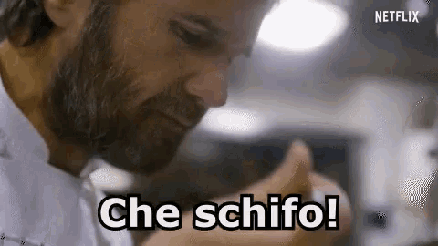 a man with a beard is cooking in a kitchen and saying che schifo !