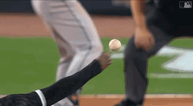 a baseball player is laying on the ground trying to catch a baseball .