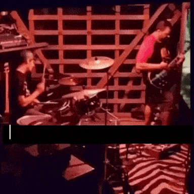 a man playing drums and a man playing a guitar on stage