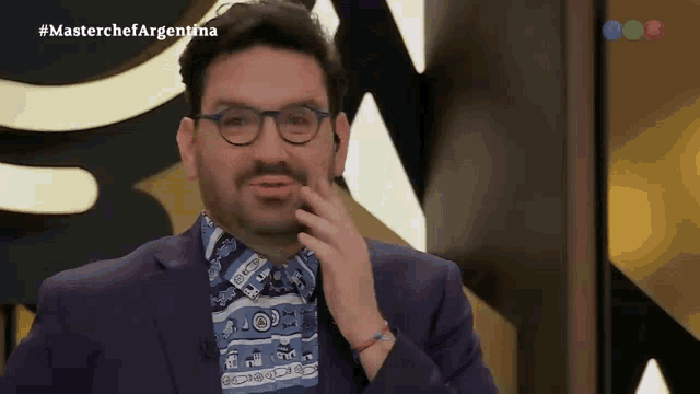 a man wearing glasses and a blue shirt is on a masterchef argentina show