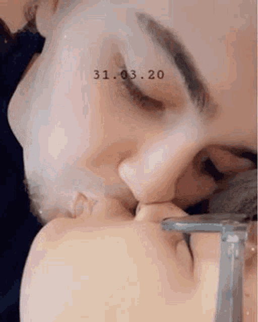 a close up of a person kissing another person 's face .