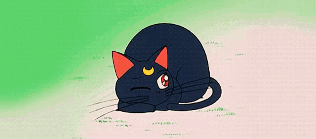 a black cat with red ears and a crescent moon is laying in the grass with its mouth open .
