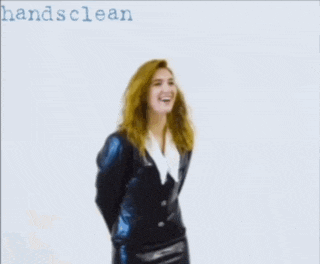 a woman in a black suit stands in front of a white background with the words hands clean on it
