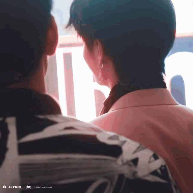 a man and a woman are standing next to each other and the woman is wearing a pink jacket that says jivino