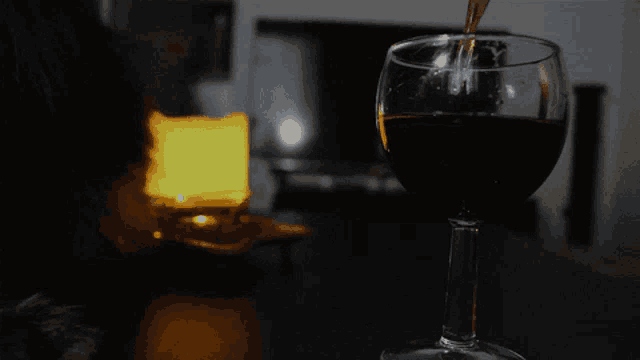 a glass of red wine is being poured into it