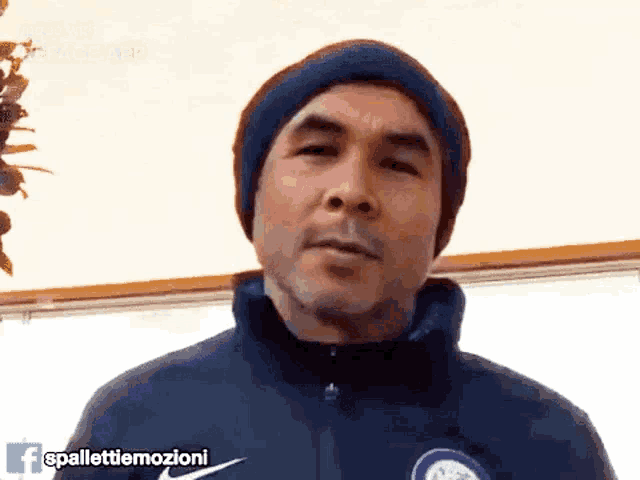 a man wearing a beanie and a nike jacket says spallettiemozioni