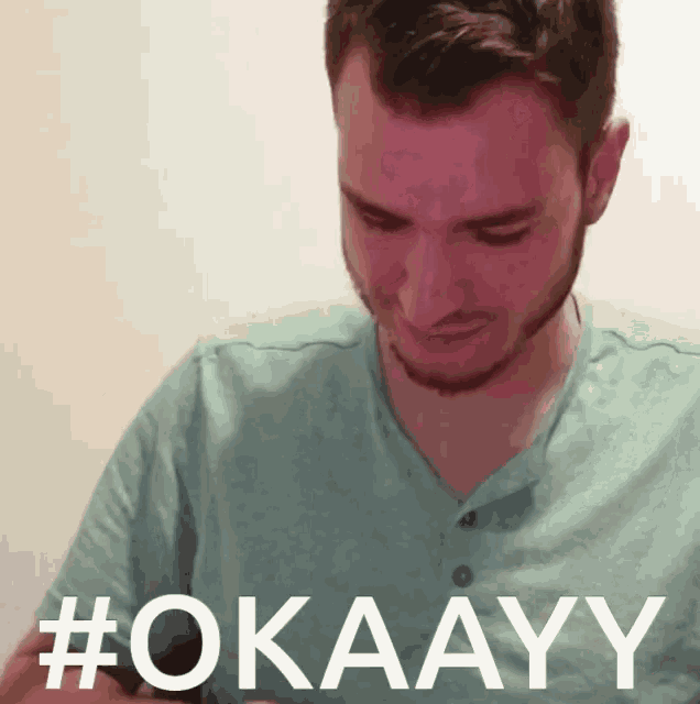 a man in a green shirt with the word okayy on the front