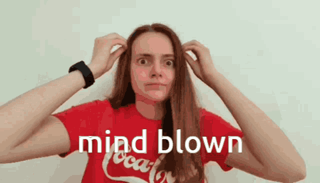 a woman wearing a red coca cola shirt is blowing her mind