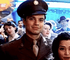 a man in a military uniform stands in a crowd of people