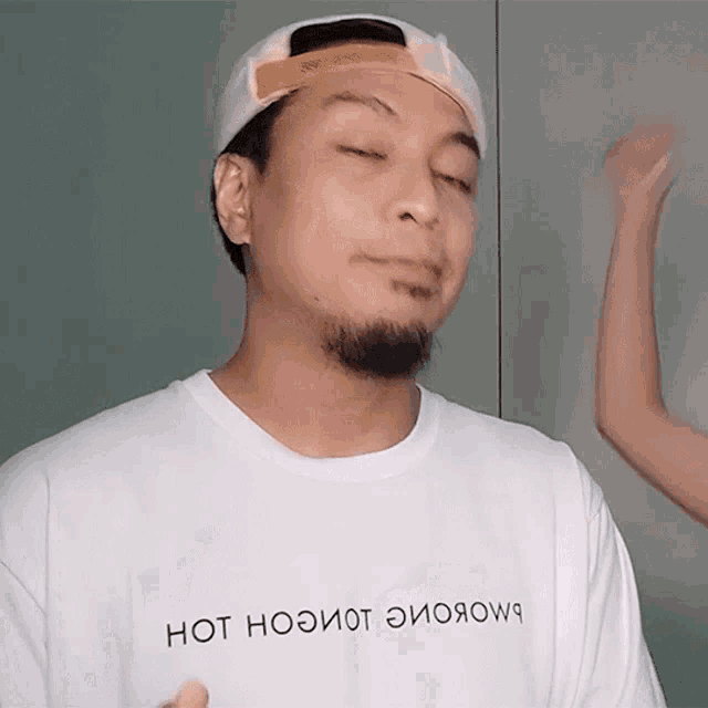 a man wearing a hat and a white shirt that says hot nooiot