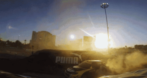 a yellow car is driving past a puma sign