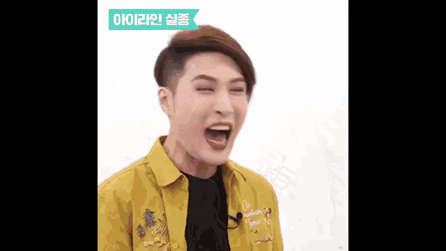 a young man wearing a yellow shirt is making a funny face with his mouth open .