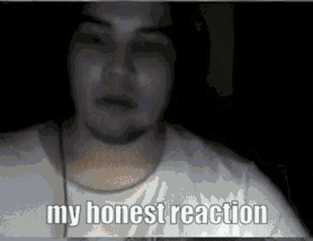 a man in a white shirt says " my honest reaction " in a dark room