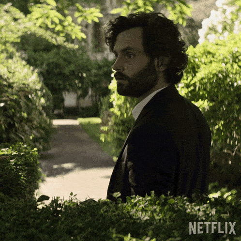 a man in a suit is standing in front of a netflix ad