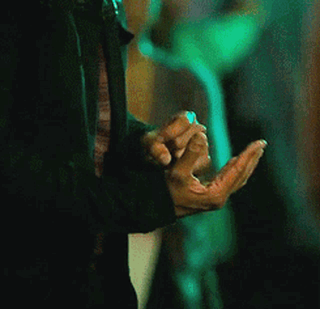 a close up of a person 's hand with a ring in it