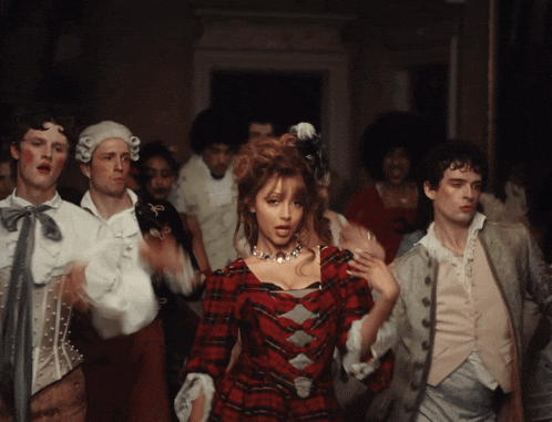 a woman in a red plaid dress is surrounded by men in fancy costumes