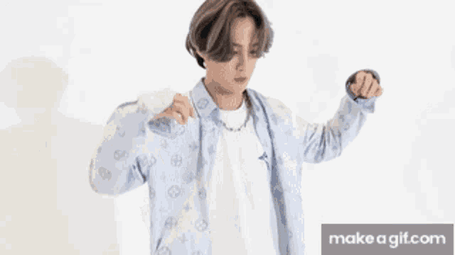 a young man in a blue shirt and white t-shirt is dancing on make a gif.com