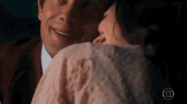 a man kissing a woman on the cheek with the letters o on the bottom right