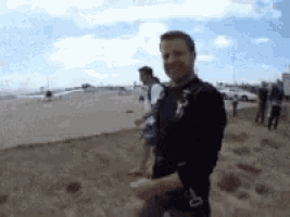 a blurry picture of a man standing on a beach with a parachute on his back .