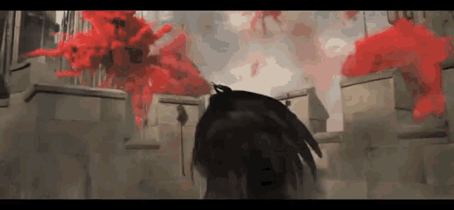 a person is standing in front of a building with red smoke coming out of it .