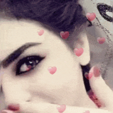a close up of a woman 's face with hearts floating around it