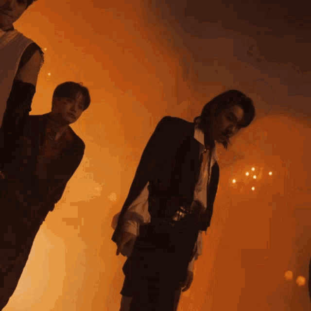 a group of men are standing in a room with smoke coming out of the ceiling