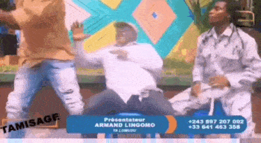 a group of men are dancing in front of a sign that says tamissage