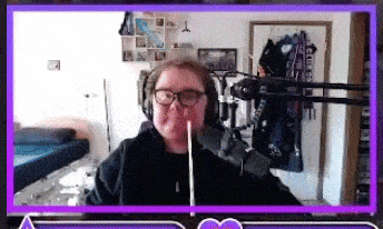 a man wearing glasses and headphones is holding a stick in his mouth while sitting in front of a microphone .