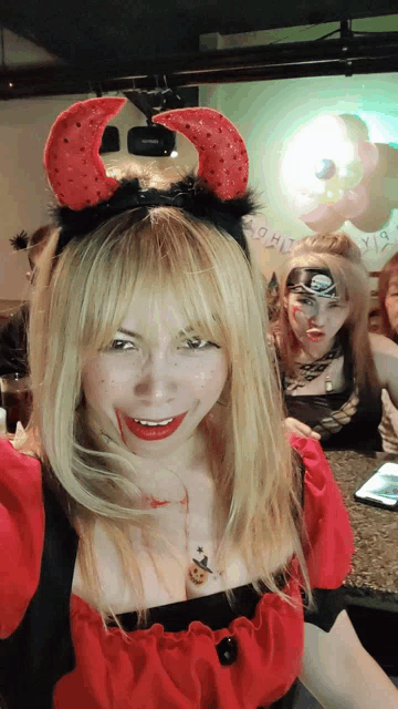 a woman wearing devil horns and a red dress