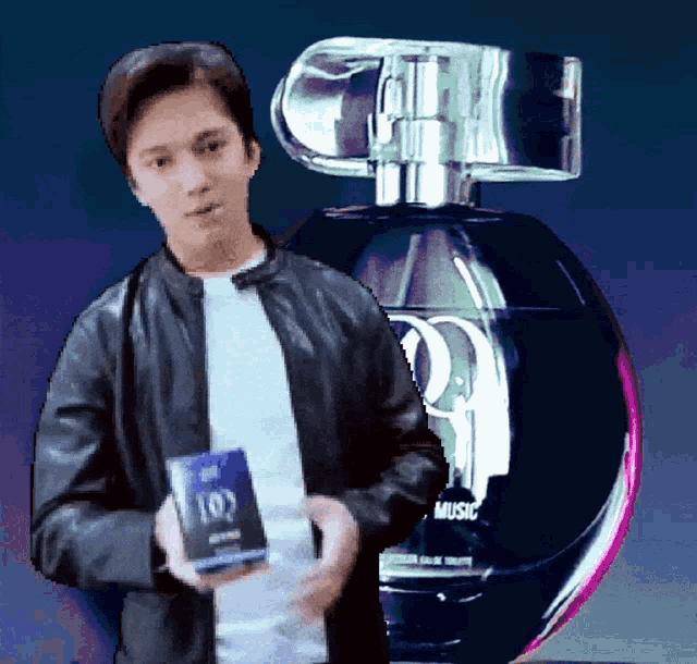 a man standing in front of a perfume bottle that says music