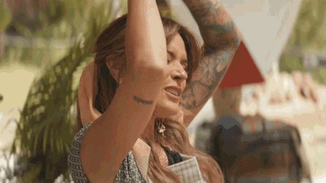 a woman with a tattoo on her arm that says ' happiness ' on it