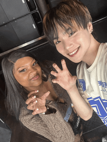 a man wearing a white shirt with the word eagle on it poses for a photo with a woman