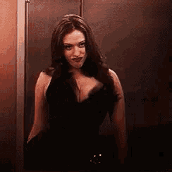 a woman in a black dress is standing in a doorway .