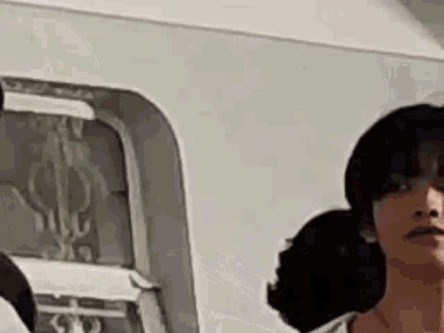 a woman is standing in front of a window on a bus .