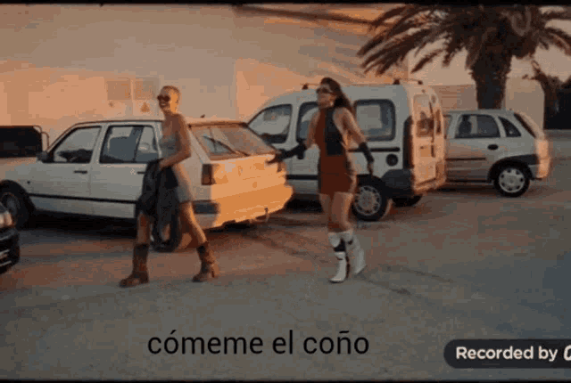 two women are walking down a street with the words comeme el cono written on the bottom