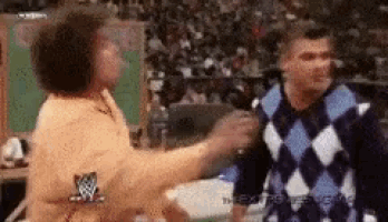 a woman in a plaid sweater is standing next to a man in a sweater .