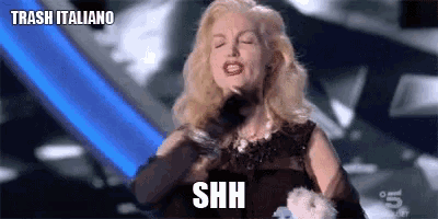 a woman in a black dress is making a shh gesture