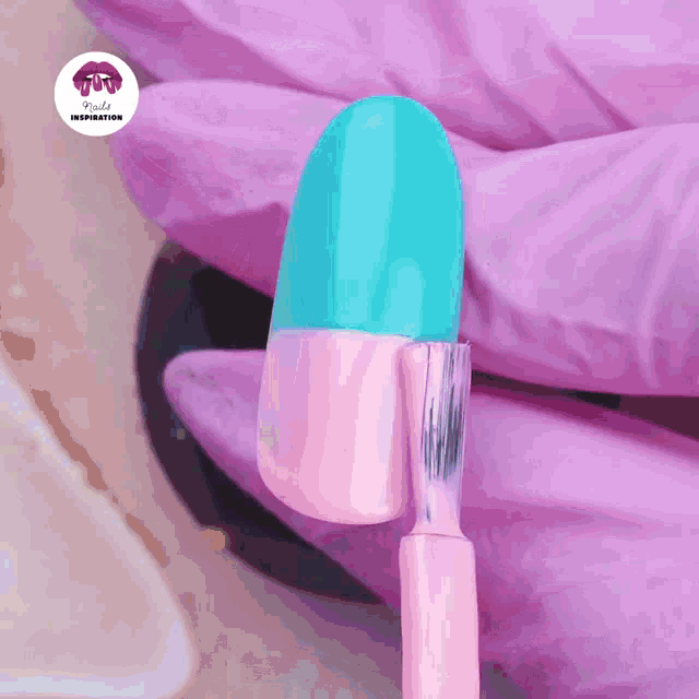 a purple glove is holding a nail with blue and pink paint on it