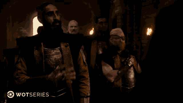 a man in a dark room with a fire in the background and the word wotseries on the bottom