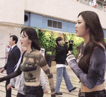 a woman in a crop top is walking with a man taking a picture