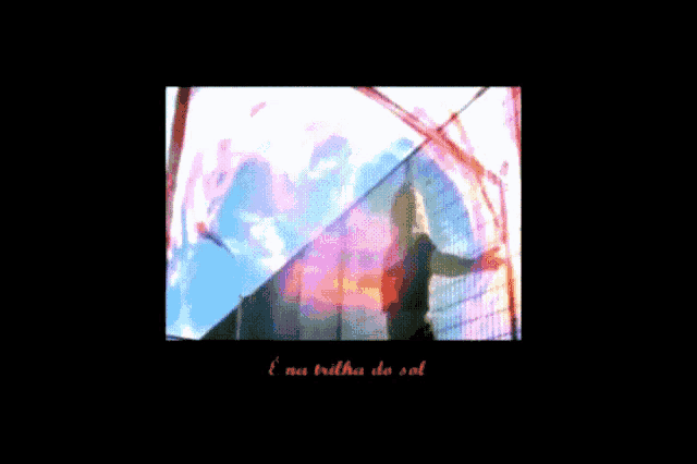 a woman is standing in front of a fence with the words e na trilha do sol below her